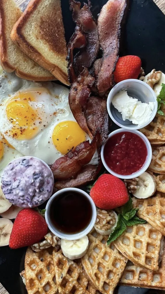 Eggs, bacon, toast, and waffles on a plate