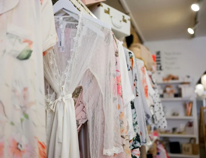 Interior of Chick Invitations with rack of clothing on display
