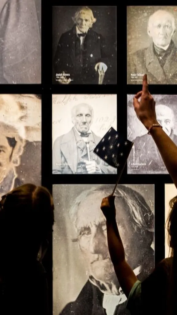Adult and child looking at wall display of photographs at the Museum of the American Revolution