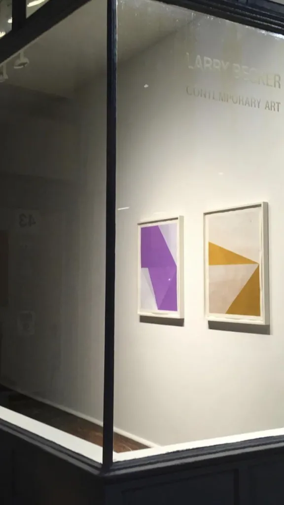 Exterior of art gallery of large window with view inside of artwork displayed on wall