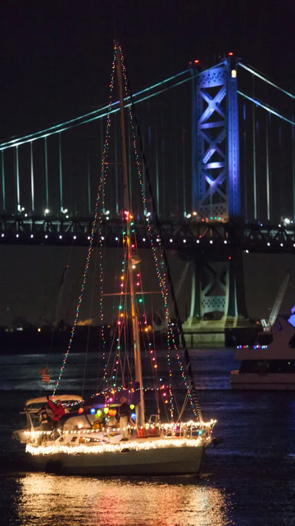Boat with holiday lights sailing on the Delaware River as part of the Parade of Lights