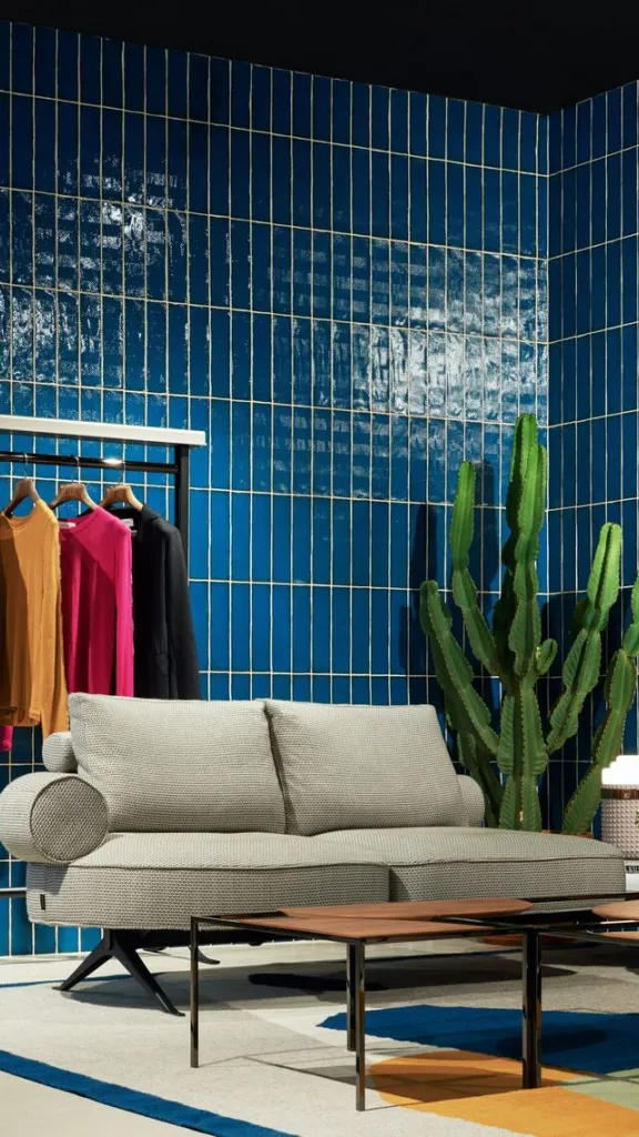 Furniture with clothing rack and plant with blue tile wall