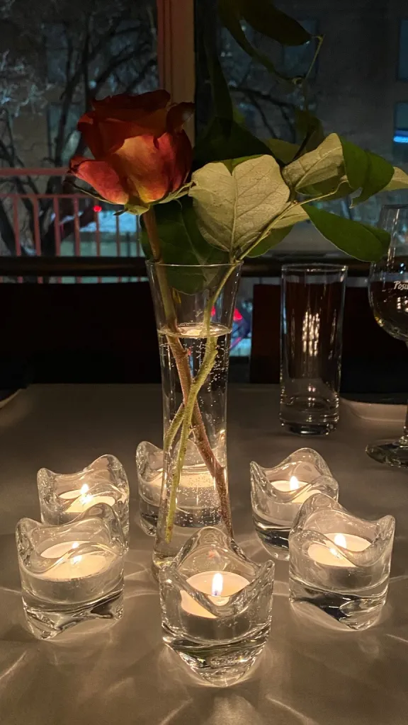 Table with candles and vase of roses
