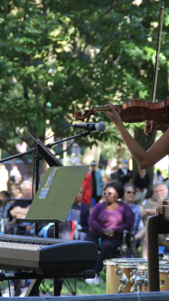 Musician playing violin in front of crowd during event