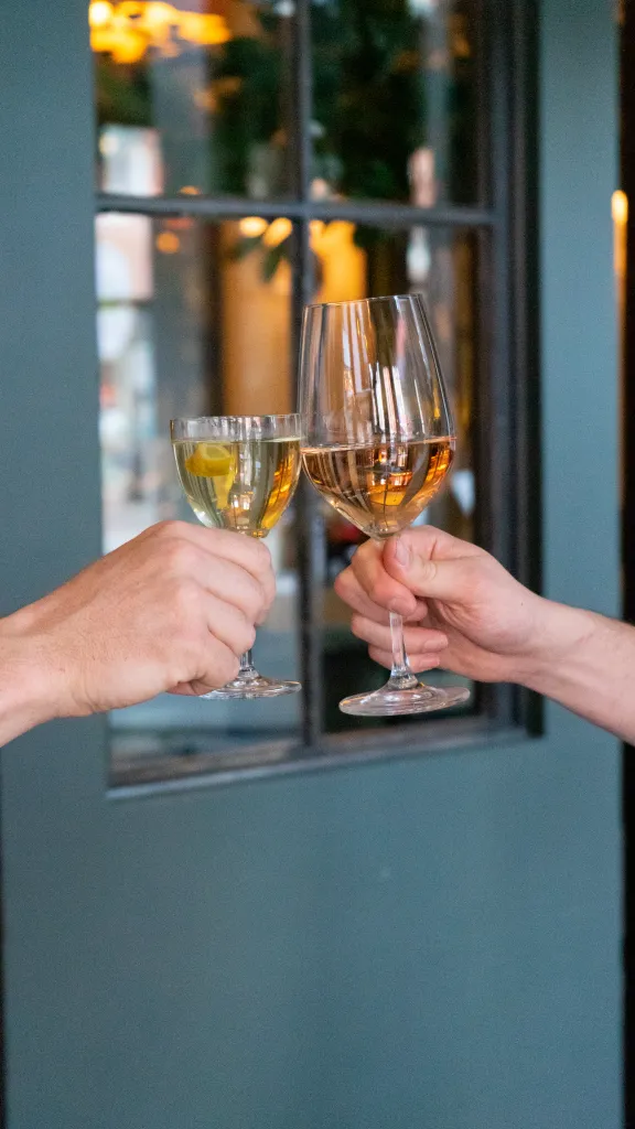 Two people holding up glasses