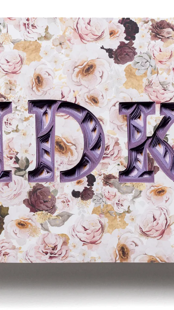 Wall hanging layered paper sculpture with bold letters spelling IDK.