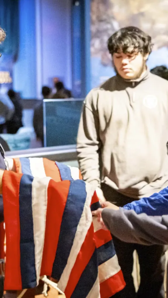 Museum of the American Revolution staff using tactile object with guests. 