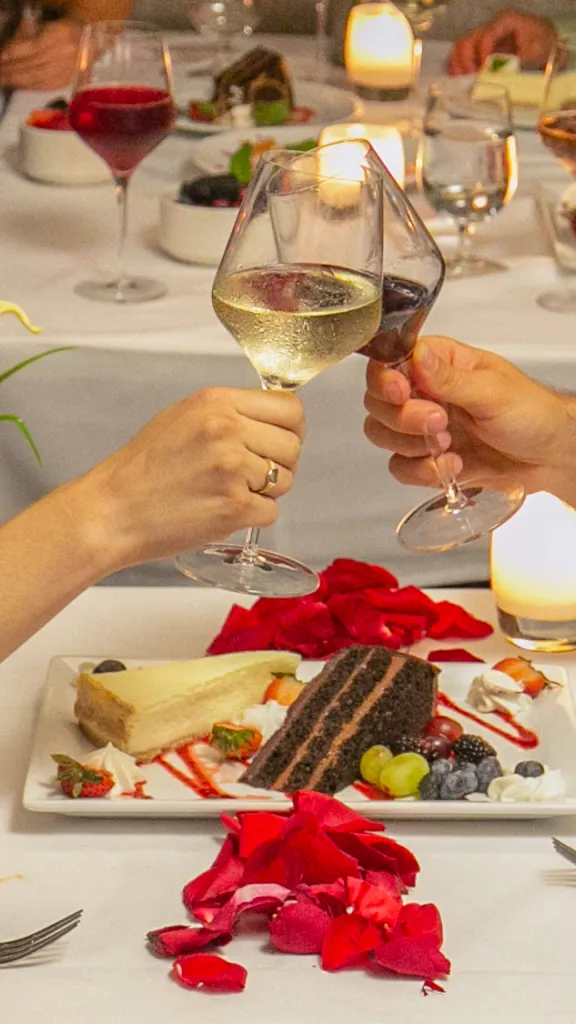 Toasting drinks with dessert on table.