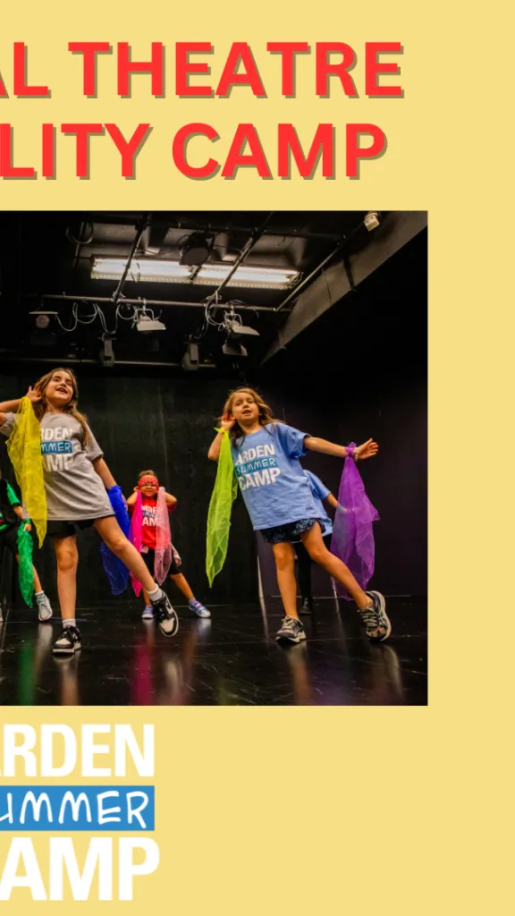 Campers dance and sing on stage facing the audience, holding colorful pieces of fabric