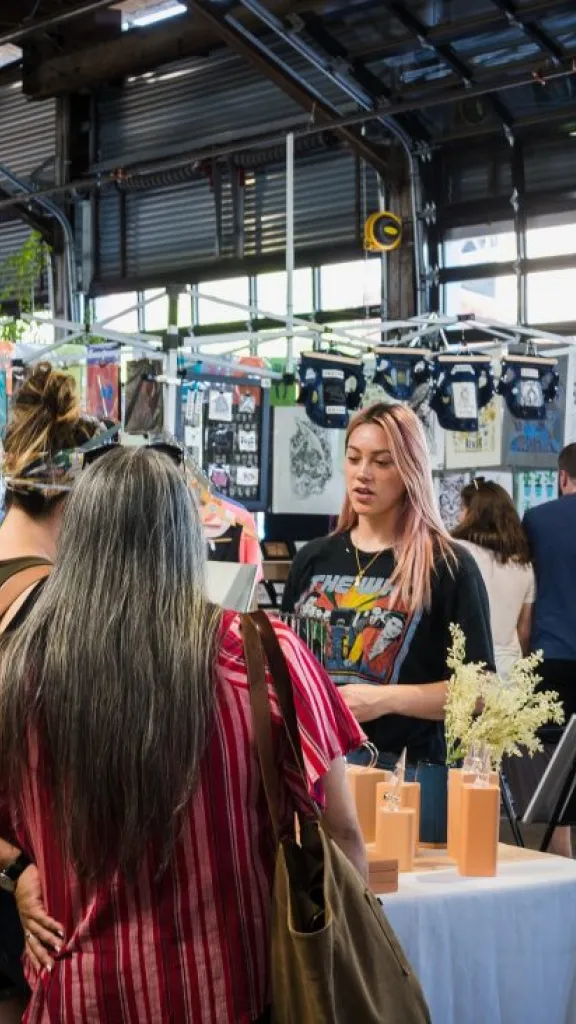People browsing vendors inside Cherry Street Pier.