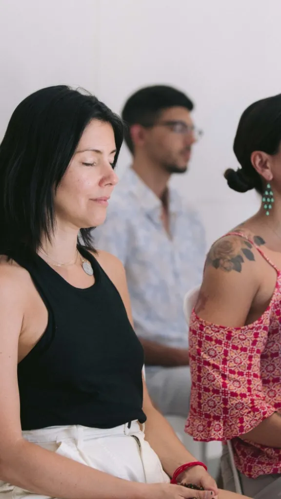 A group of people sitting in chairs, meditating.