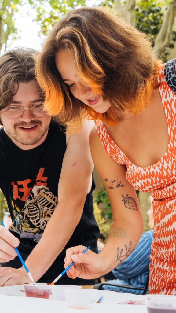 Two people creating art at a Ministry of Awe First Friday event at the Betsy Ross House.