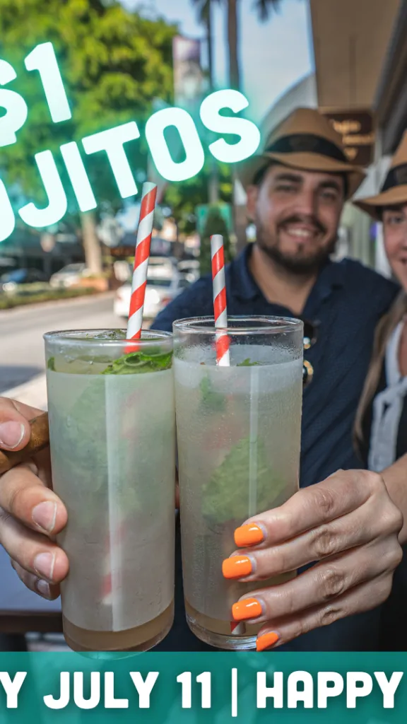 A man and woman holding classic mojitos and smiling