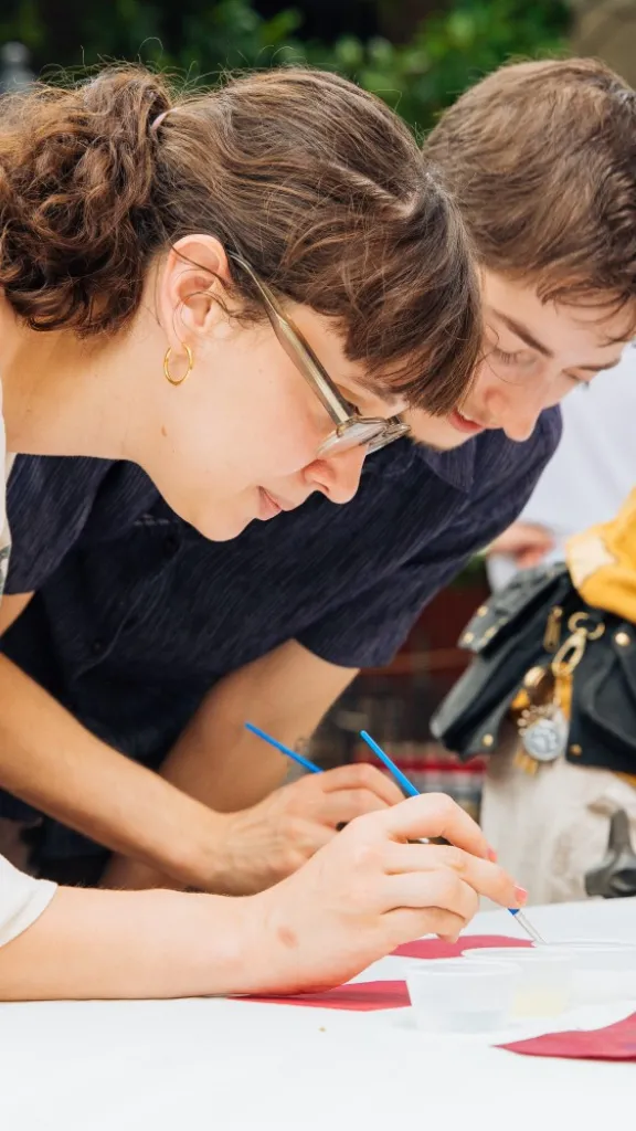 People participating in interactive art activity at a Ministry of Awe First Friday event.