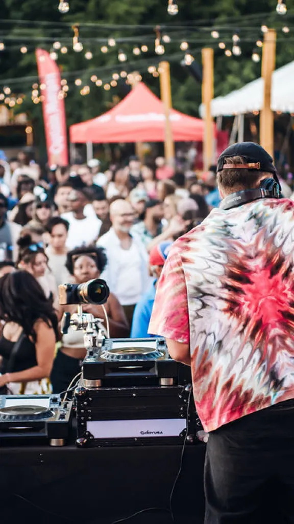 Cosmic Rhythms performing at Spruce Street Harbor Park venue with a crowd in the background.
