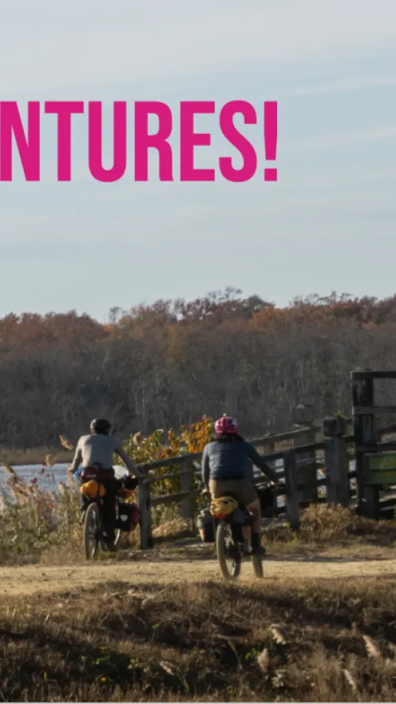 Photo of three people riding bikes about to cross a bridge