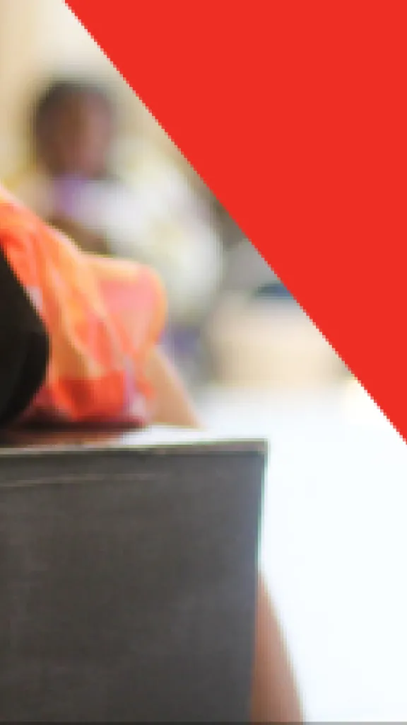 A child leans upside down over the top of a black box and splays their hands out forward. Text that reads "Play-in-a-Day" and "Grades K-5"