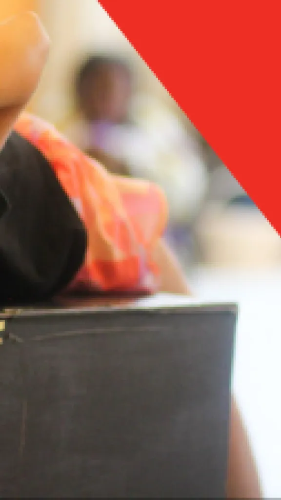 A child leans upside down over the top of a black box and splays their hands out forward. Text that reads "Play-in-a-Day" and "Grades K-5"