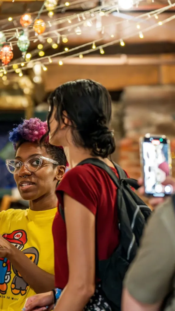 Artists and attendees doing rug tufting at a Ministry of Awe event.