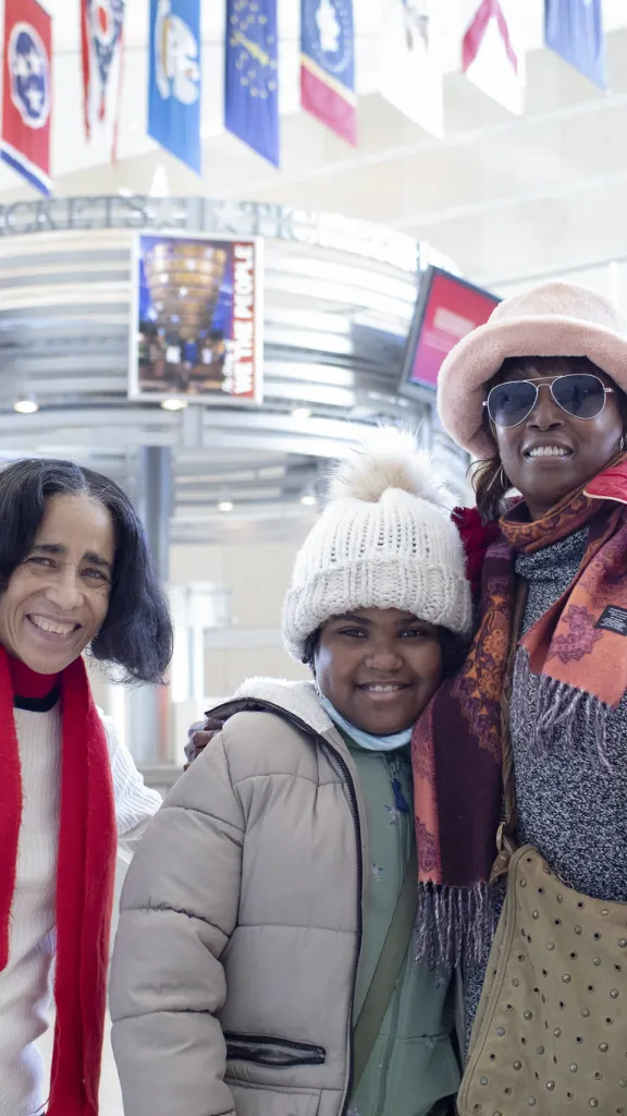 A family of three smiles in the lobby of the NCC.