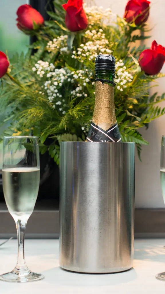 Roses and champagne on table.