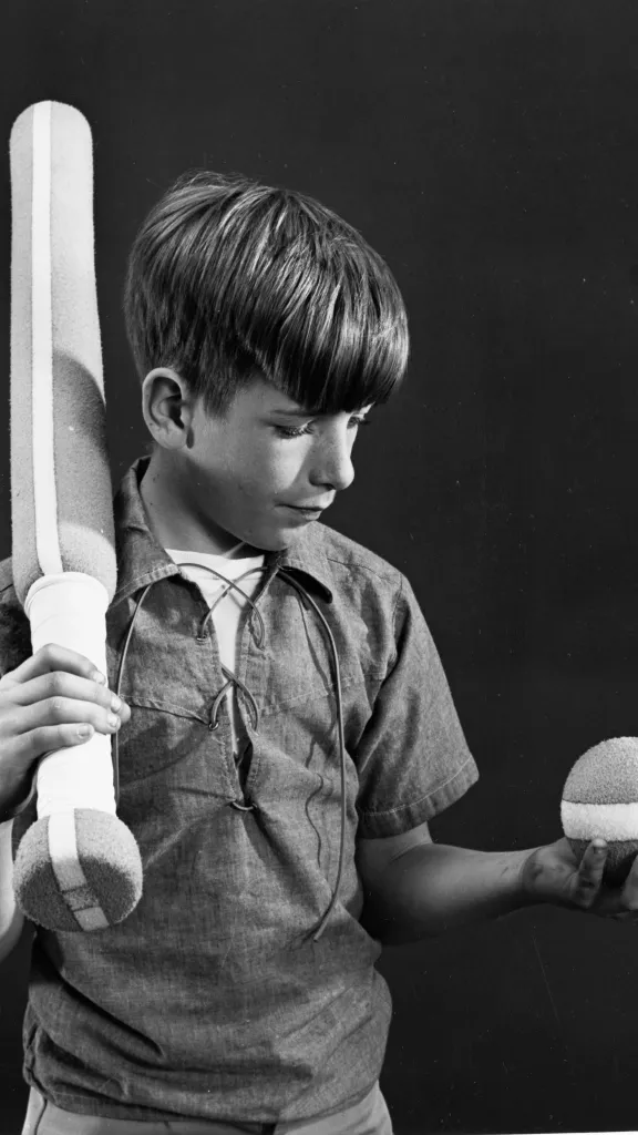 black and white photo of a boy and baseball gear