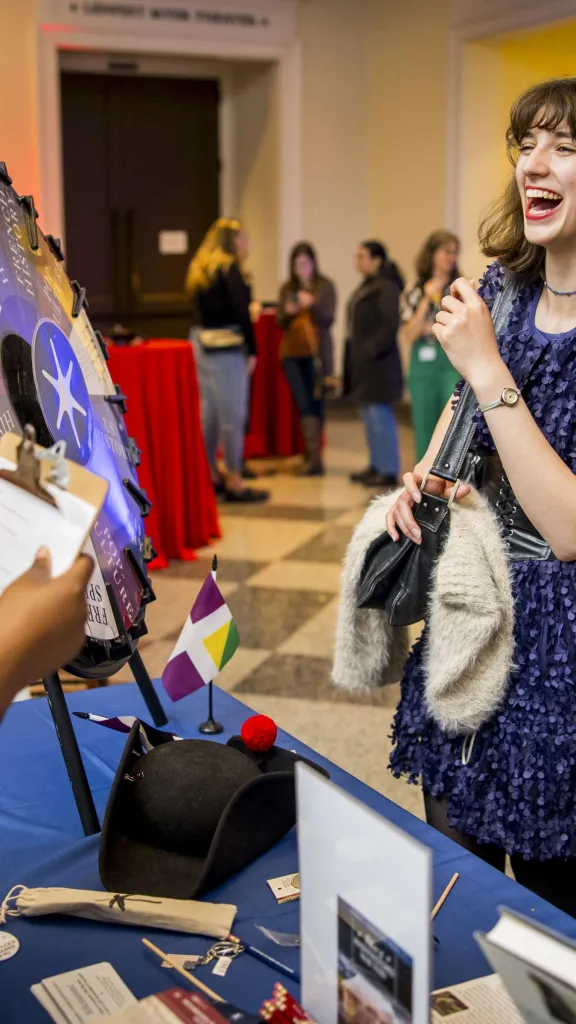 Woman with brown hair and navy blue dress smiles