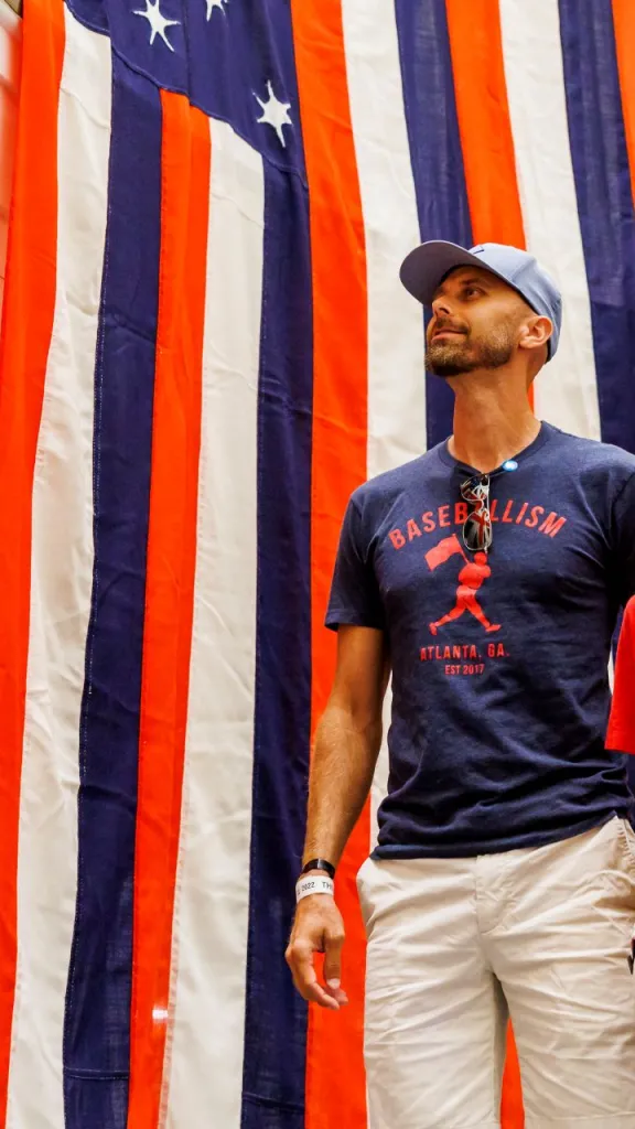 Man and teenage boy look at red, white, and blue flags