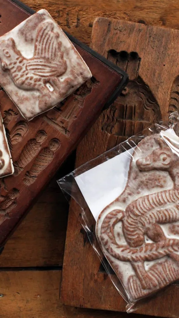 gingerbread cookies in the shape of animals on wooden antique cookie molds