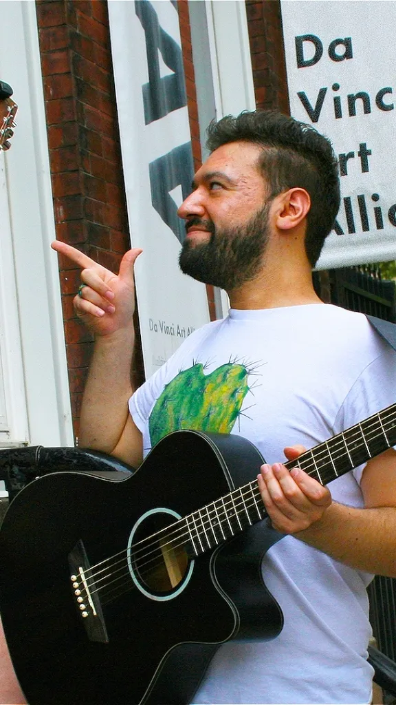 Two musicians smiling with their guitars posing outside of DVAA.