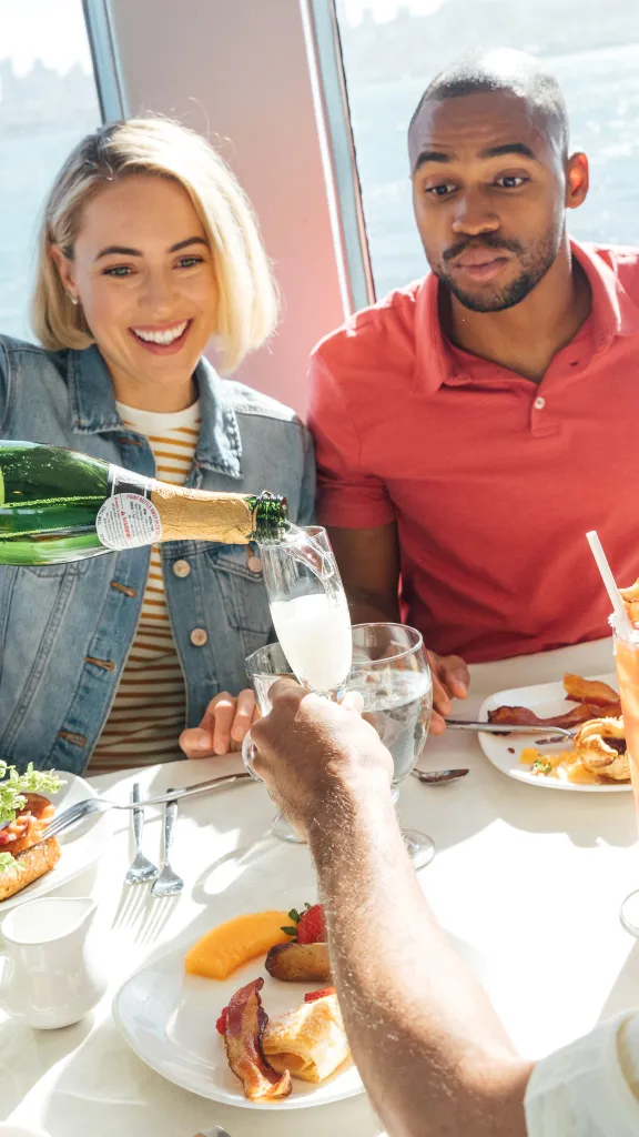 Guests pouring champagne on boat