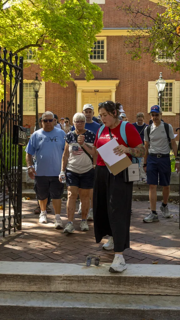 Group of people walking through front gate of Arch Street Meeting House