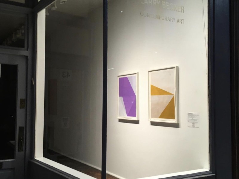 Exterior of art gallery of large window with view inside of artwork displayed on wall