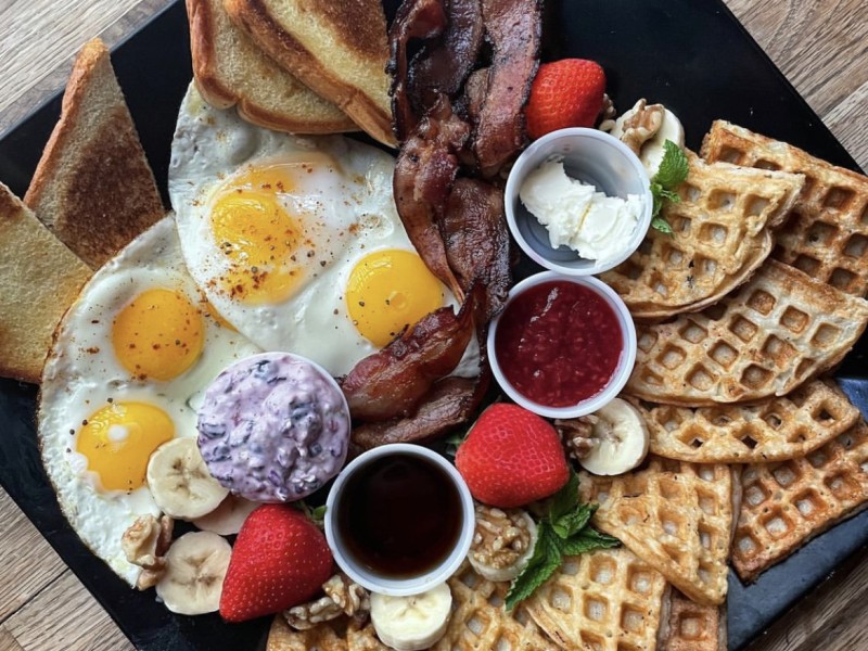 Eggs, bacon, toast, and waffles on a plate