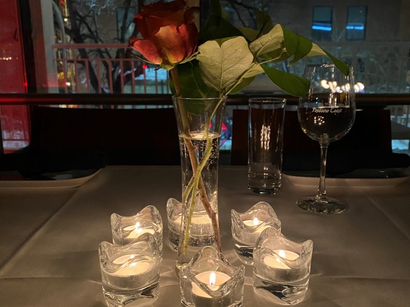Table with candles and vase of roses