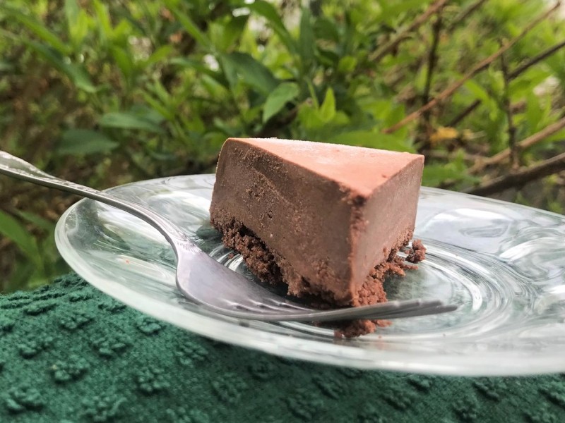 A slice of chocolate cheesecake on a plate with a fork