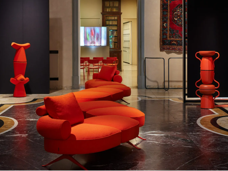 Orange furniture on display in living room with blue walls and marble floor