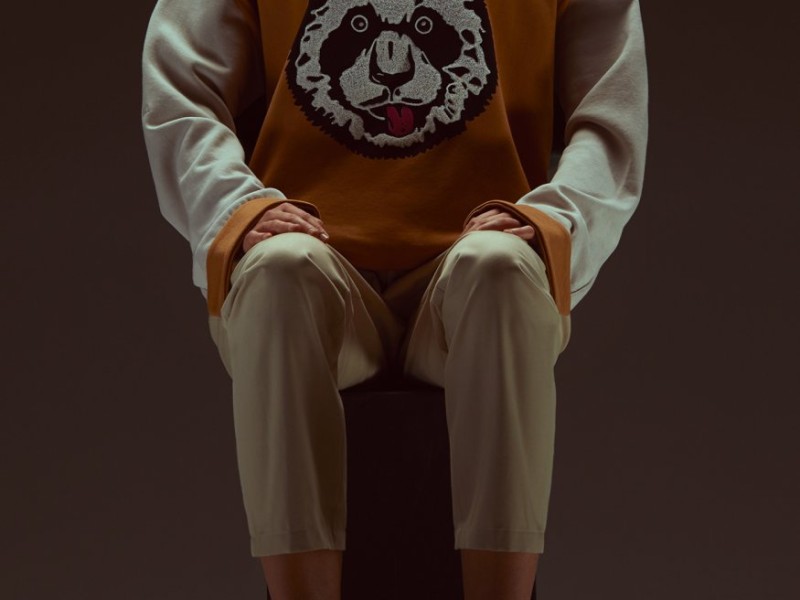 Person seated wearing sweatshirt with panda 