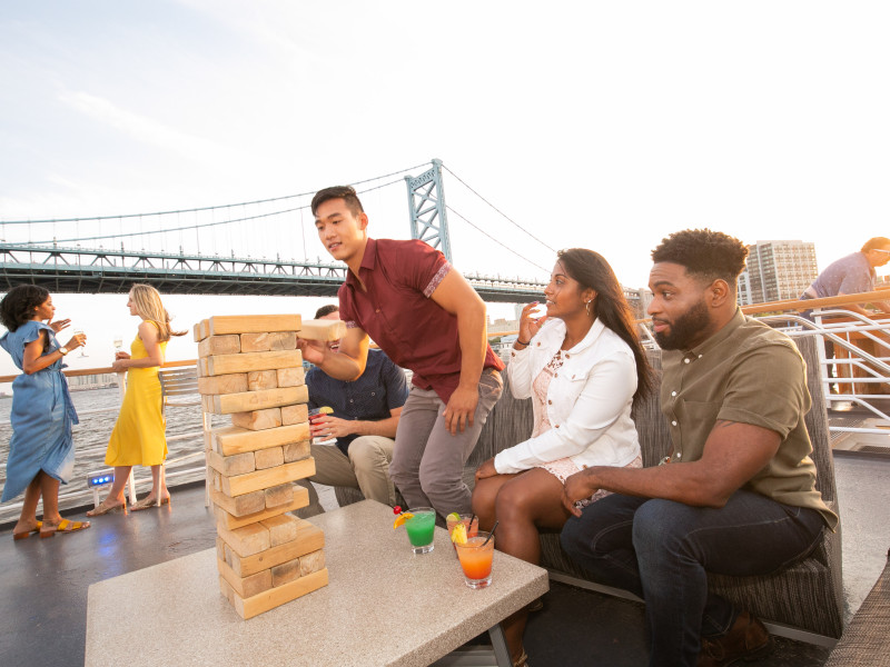 People playing the game jenga on the top deck. 