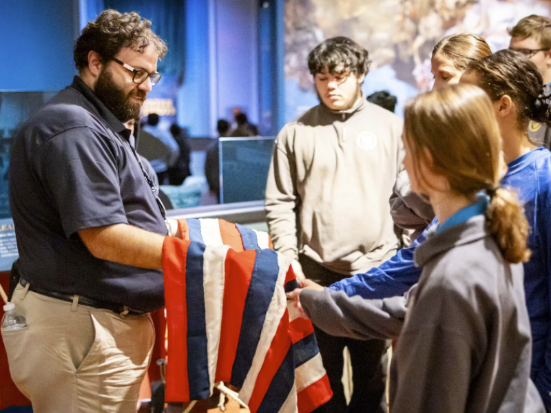 Museum of the American Revolution staff using tactile object with guests. 