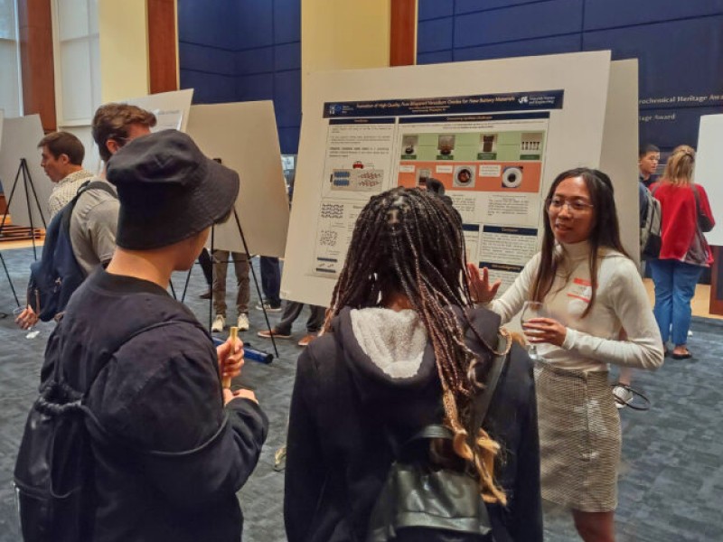 people talking in front of a poster
