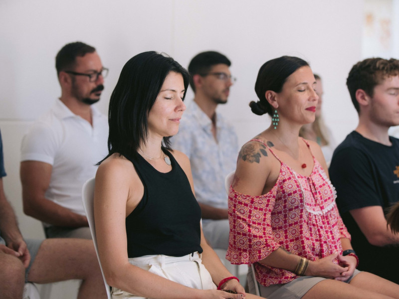 A group of people sitting in chairs, meditating.
