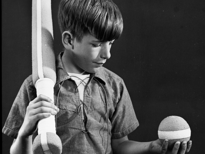 black and white photo of a boy and baseball gear