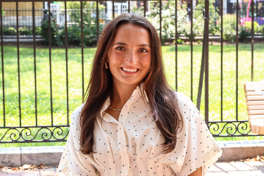 headshot of janine standing in front of fence outside christ church