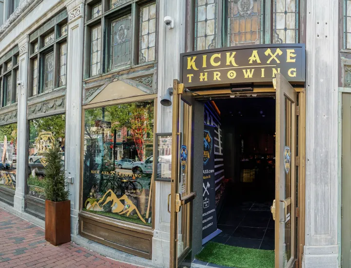Exterior of Kick Axe Throwing with open front door and large front display windows