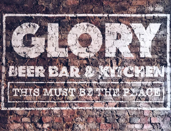 Glory Beer Bar & Kitchen logo on brick wall