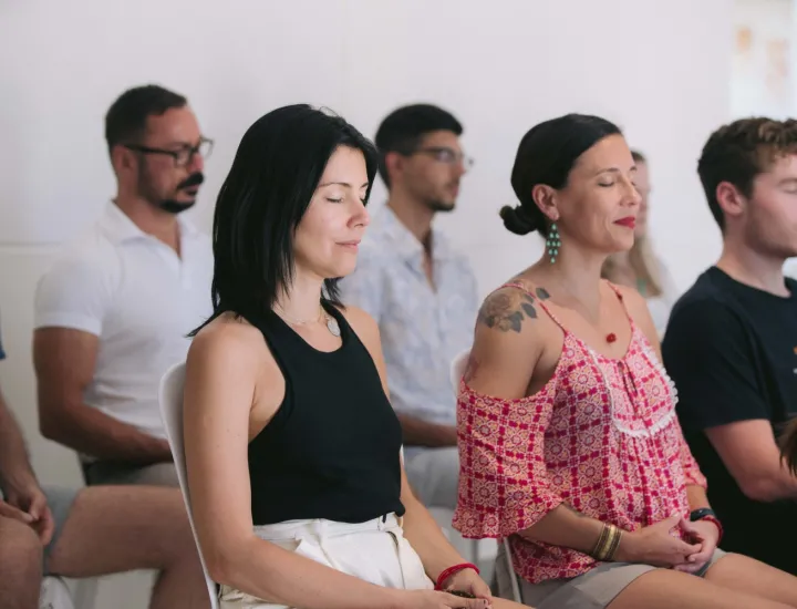 A group of people sitting in chairs, meditating.