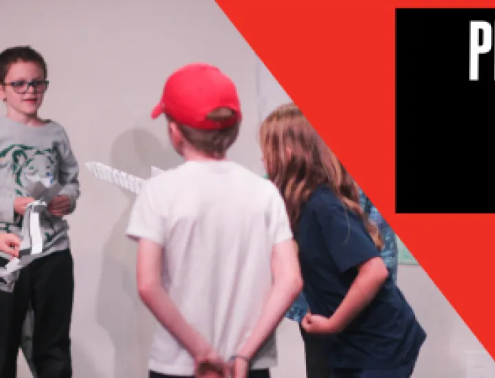 A boy in a green striped shirt holds a paper in his hand and makes a funny, scrunched face. Other children hold papers in a similar way. Text that reads "Play-in-a-day" and "Grades K-5."