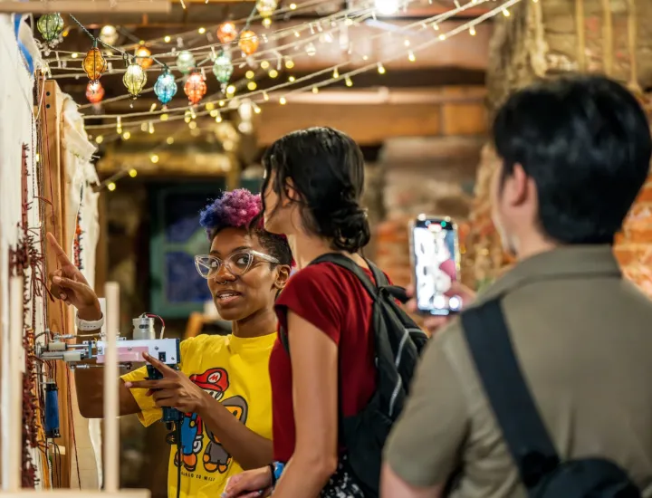 Artists and attendees doing rug tufting at a Ministry of Awe event.