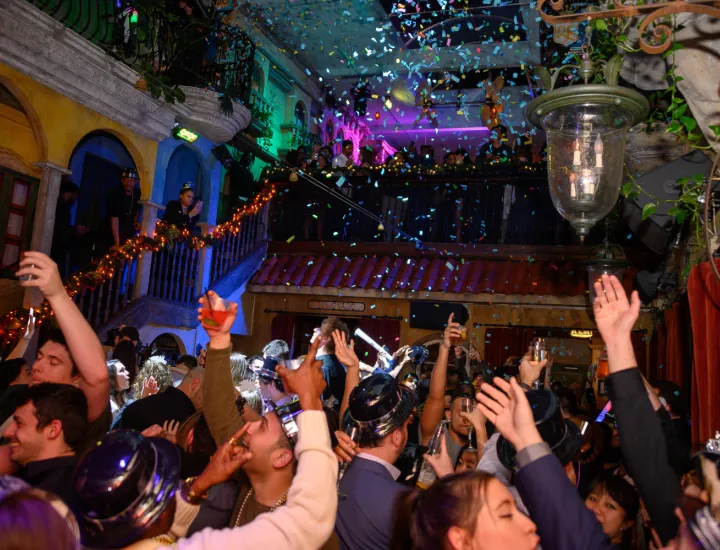 Guests celebrating New Year's Eve and dancing on the dance floor while confetti rains down